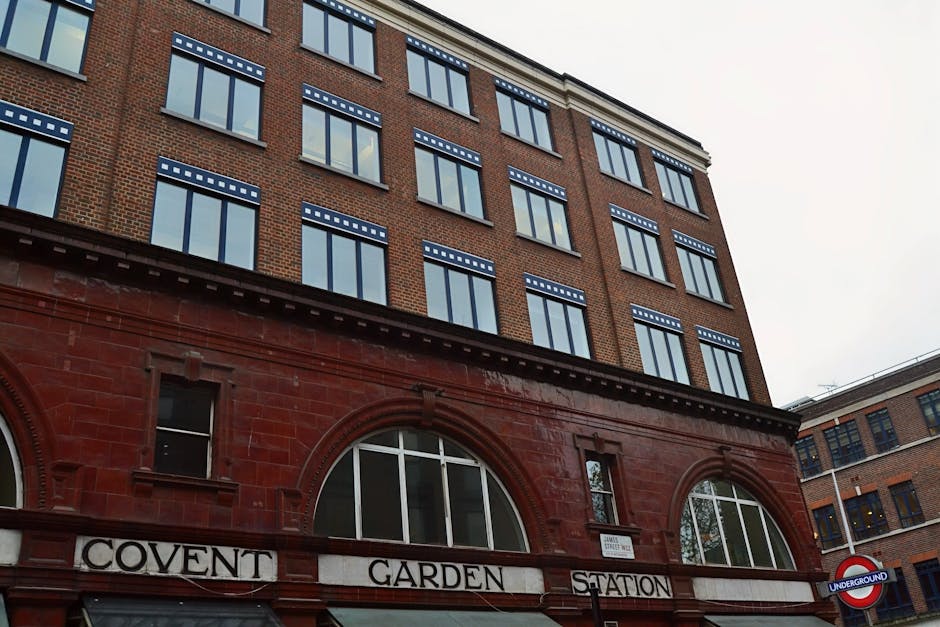 Exterior view of the historic Covent Garden Station building in Westminster SW1, featuring red brick and stone construction with large arched windows and decorative detailing. The signage indicates th